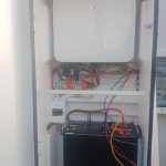 Inverter enclosure opened to show DC and AC wiring during commissioning