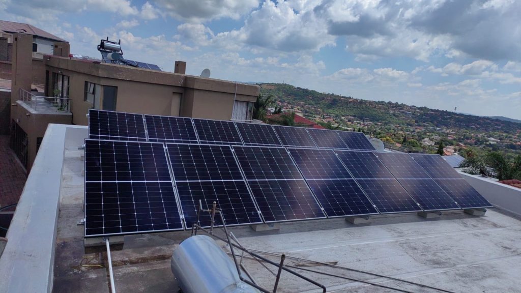 Rooftop solar array mounted on a residential flat roof with parapet