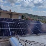Rooftop solar array mounted on a residential flat roof with parapet