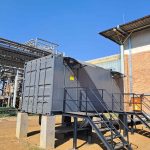 Containerised unit positioned next to a bulk storage facility