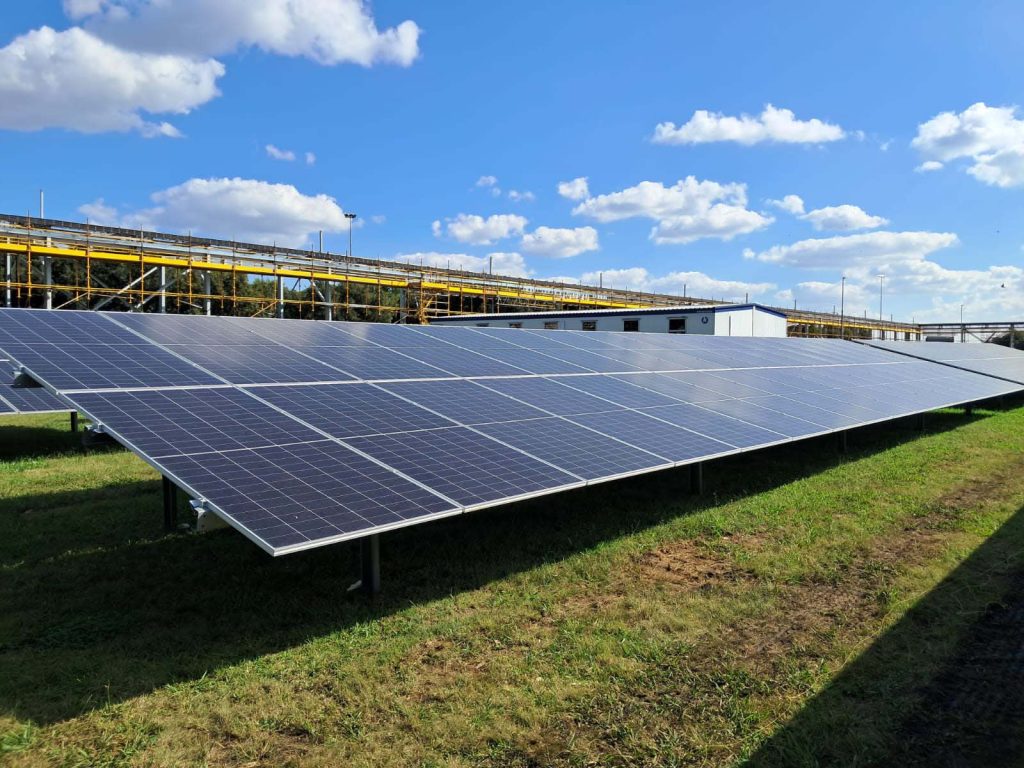 Ground-mounted solar panels on a landscaped area at a commercial premises